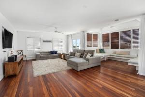 ein Wohnzimmer mit 2 Sofas und einem TV in der Unterkunft 75 Lorikeet Drive Peregian Beach in Peregian Beach