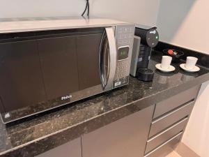 a microwave oven sitting on a counter in a kitchen at Studios Soho Bongiovani in Presidente Prudente
