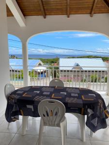mesa de comedor con sillas y vistas al océano en KARIFUNA-II, en Baie Mahault