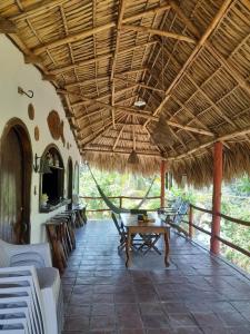 un patio con mesa y techo de paja en Casa Villa Pesca, en Monterrico