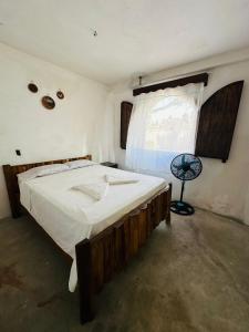 a bedroom with a large bed and a window at Casa Villa Pesca in Monterrico