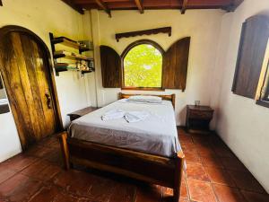 een slaapkamer met een bed in een kamer met een raam bij Casa Villa Pesca in Monterrico