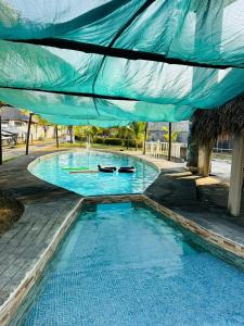 a swimming pool with a blue tarp over it at Casa Villa Pesca in Monterrico