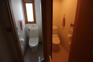 a small bathroom with a toilet and a window at ゲストハウス樹舎 in Minami-jūichijō +6 photos