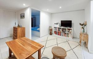 uma sala de estar com uma mesa e uma televisão em Stunning Home In Le Bouscat With Kitchen em Le Bouscat