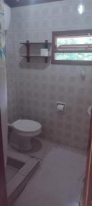 a bathroom with a toilet and a window at Casa da Cíntia in Visconde De Maua