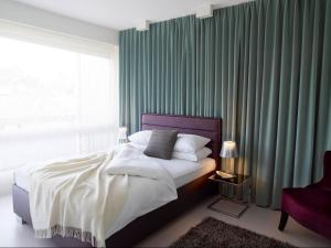 Schlafzimmer mit einem Bett mit grünen Vorhängen und einem Fenster in der Unterkunft VISIONAPARTMENTS Rue Caroline - contactless check-in in Lausanne