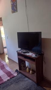 TV de pantalla plana en la mesa de la sala de estar en Casa da Cíntia en Visconde De Maua