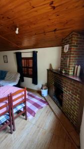 a living room with a brick fireplace and a bed at Casa da Cíntia in Visconde De Maua