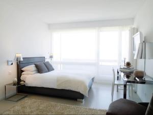 een slaapkamer met een bed, een bureau en een raam bij VISIONAPARTMENTS Rue Caroline - contactless check-in in Lausanne