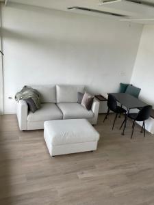 ein Wohnzimmer mit einem weißen Sofa und einem Tisch in der Unterkunft Studio met frontaal zeezicht en afgesloten slaaphoek in De Panne