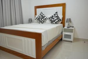 a bedroom with a large bed with white sheets and pillows at Apartamento Marla Comodo y cerca del aeropuerto in Santo Domingo