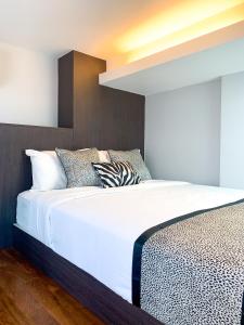 a bedroom with a bed with white sheets and pillows at Heritage Collection on Seah - Mobile App Check-In in Singapore