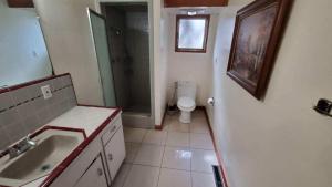 a bathroom with a toilet and a sink and a mirror at Home in Santa Cruz in Santa Cruz