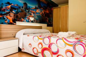 a bedroom with a bed with a colorful wall at Pension Teresa in Calahorra
