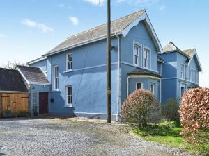 une maison bleue avec une allée dans l'établissement Gymmin House, à Pendine