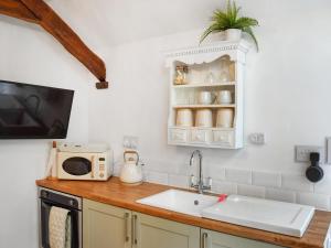 a kitchen with a sink and a microwave at Dove House 