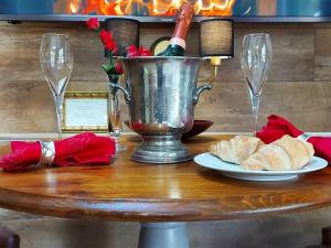 einen Tisch mit einem Eimer und einem Teller Brot und Weingläser in der Unterkunft The Lodge in Llangelynin