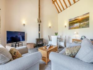 a living room with two couches and a tv at Chapel Barn - Uk46738 in Shapwick