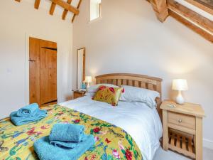 a bedroom with a bed with a wooden headboard at Chapel Barn - Uk46738 in Shapwick