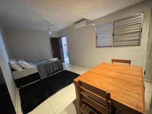 Cette petite chambre comprend un lit et une table en bois. dans l'établissement Casa confortável, Temporada Votuporanga, à Votuporanga