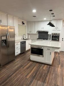una cucina con armadietti bianchi ed elettrodomestici in acciaio inossidabile di Sequoia Villa a Visalia