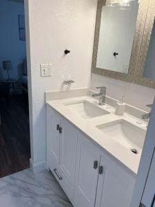 bagno bianco con lavandino e specchio di Sequoia Villa a Visalia
