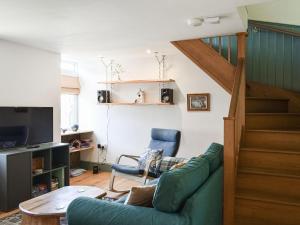 - un salon avec un canapé vert et un escalier dans l'établissement Treacle Corner - Uk47039, à Bempton