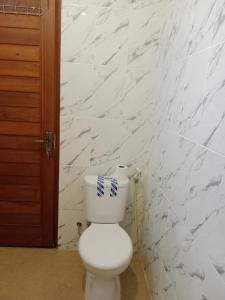 a bathroom with a white toilet with a paper on it at SUNRISE HOUSE in Ubud