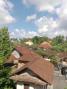 a group of houses with red roofs and trees at SUNRISE HOUSE in Ubud