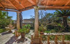un patio al aire libre con una pérgola de madera con plantas en Lovely Home In Santa Croce Camerina With Kitchen, en Santa Croce Camerina