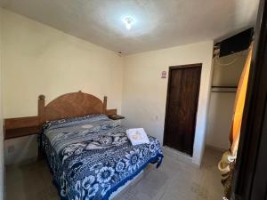 een slaapkamer met een bed met een blauwe deken bij Hotel Casa De Los Abuelos in Bernal