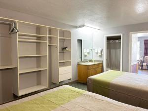 a bedroom with two beds and a bathroom with a sink at Coronada Inn & Suites in St. George