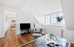 a living room with a television and a chair at 1 Bedroom Cozy Apartment In Gilleleje in Gilleleje