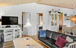 DannemareにあるStunning Home In Dannemare With 4 Bedrooms, Sauna And Wifiのリビングルーム(黒いソファ、テレビ付)