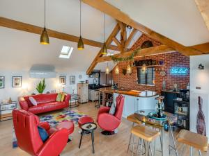 ein Wohnzimmer mit roten Möbeln und einer Ziegelwand in der Unterkunft Country Escape At The Granary in Copford