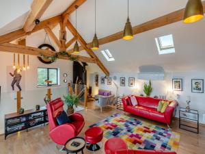 a living room with a red couch and red chairs at Country Escape At The Granary in Copford