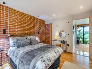 a bedroom with a brick wall and a bed at Country Escape At The Granary in Copford
