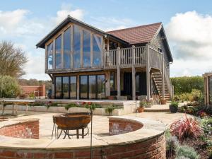 ein großes Haus mit einer Terrasse und einem Innenhof in der Unterkunft Country Escape At The Granary in Copford