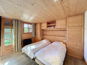 sypialnia z łóżkiem w drewnianym pokoju w obiekcie Superbe chalet au calme avec jardin, garage et Wifi - FR-1-560-130 w mieście Combloux