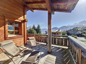 dwa krzesła na tarasie z górami w tle w obiekcie Superbe chalet au calme avec jardin, garage et Wifi - FR-1-560-130 w mieście Combloux