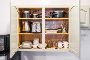 un armario de cocina lleno de platos, ollas y sartenes en Park Side Living, Get Cozy, en Nueva York