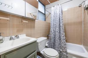 y baño con lavabo, aseo y ducha. en Park Side Living, Get Cozy, en Nueva York