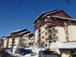 un grand immeuble avec des voitures garées dans la neige dans l'établissement Appartement Peisey-Vallandry, 2 pièces, 4 personnes - FR-1-411-940, à Landry