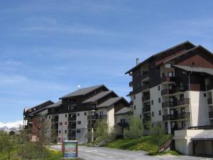 un grupo de edificios con montañas en el fondo en Appartement Peisey-Vallandry, 2 pièces, 4 personnes - FR-1-411-940, en Landry