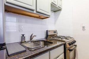a kitchen with a sink and a stove at Park Side Living, Get Cozy in New York