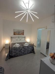 a bedroom with a black and white bed and a chandelier at Rovelli House in Foggia