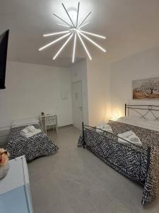 a bedroom with two beds and a chandelier at Rovelli House in Foggia