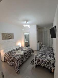 a bedroom with a bed and a table and a television at Rovelli House in Foggia