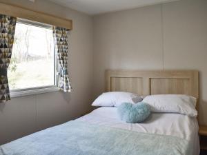a bedroom with a bed with a blue pillow on it at Forest View 